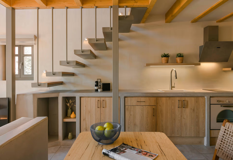 Kitchen beneath a cantilevered timber stair