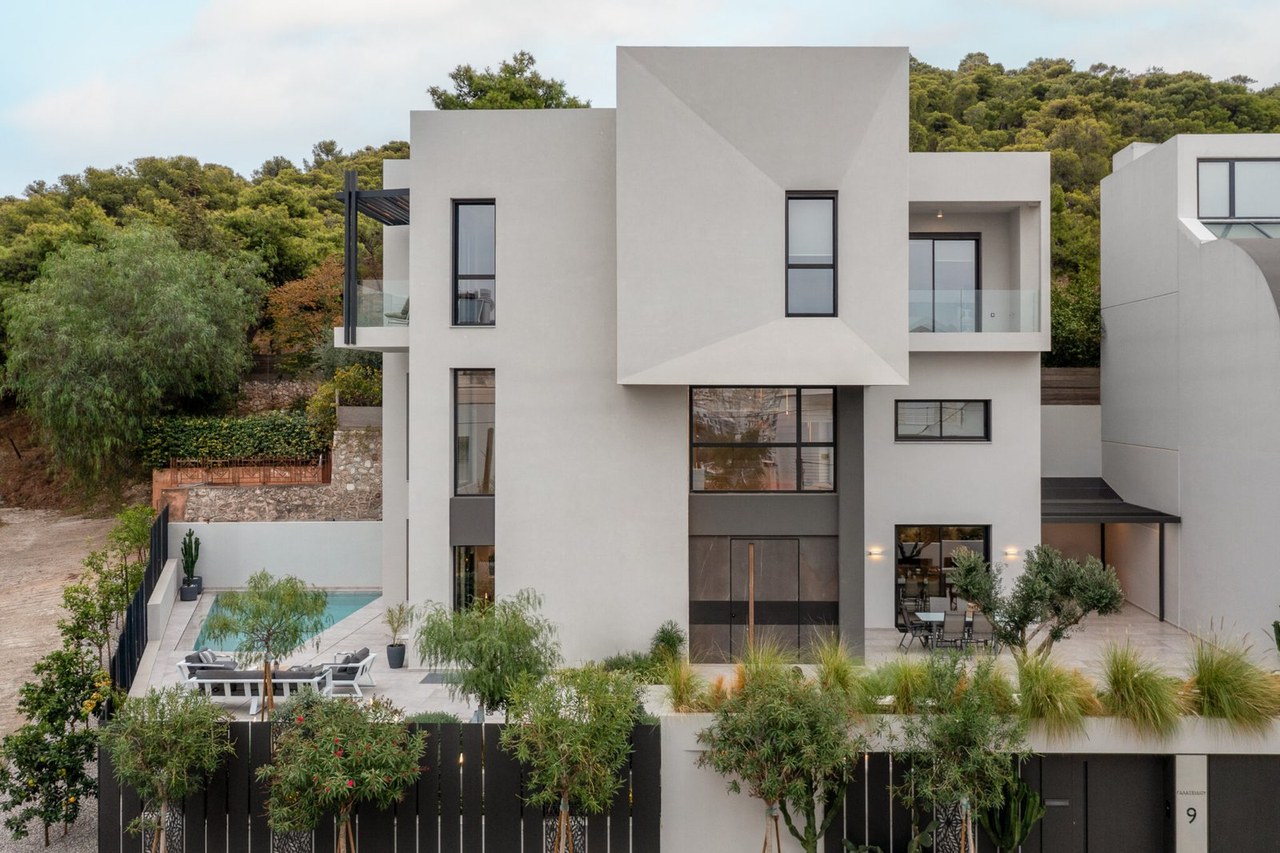 The house above its garden and pool